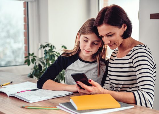 Mamá le muestra a su hija información de su celular