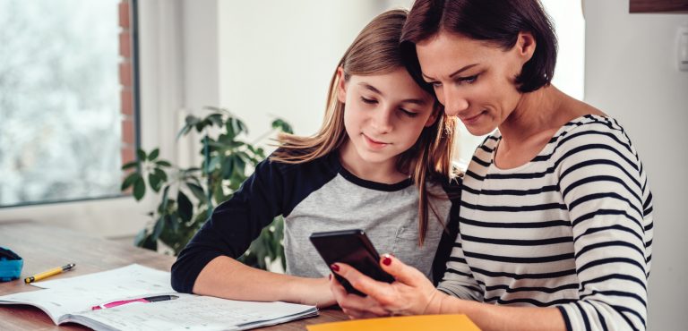 Mamá le muestra a su hija información de su celular