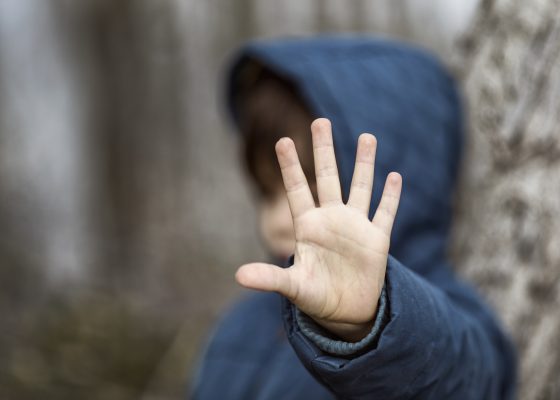 Niño con la mano levantada