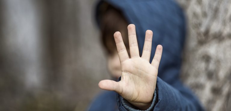 Niño con la mano levantada