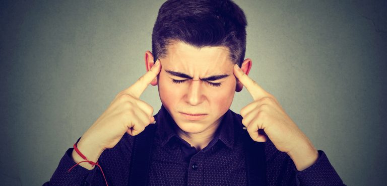 Niño con dedos apuntando sus cejas