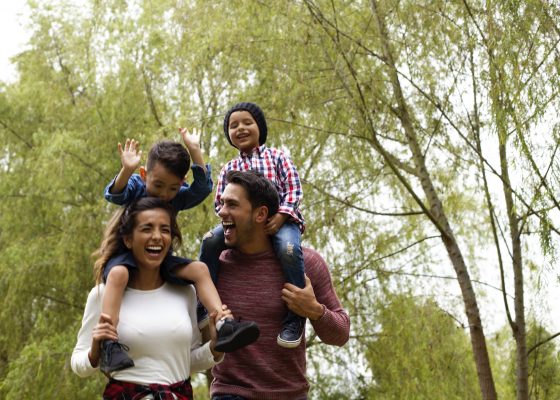 Padre con hijos sentado sobre sus hombros