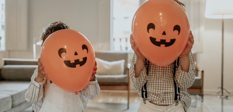 niños con globos de halloween de máscara