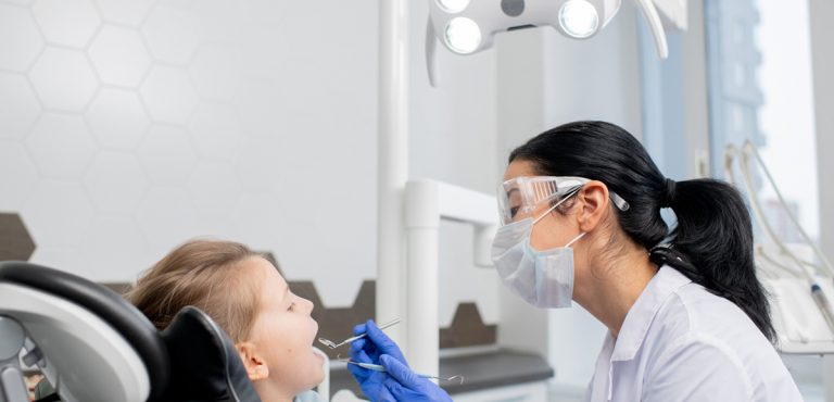 Odontólogo revisa a los dientes de un niño
