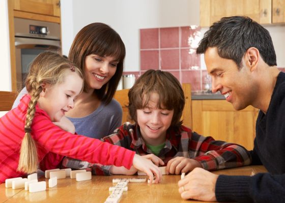 Padres y niños jugando dominó