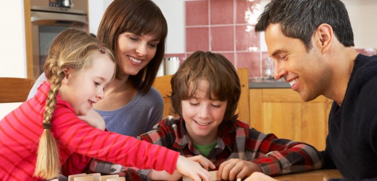 Padres y niños jugando dominó