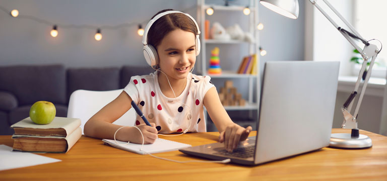 Niña con audífono estudiando en su computador